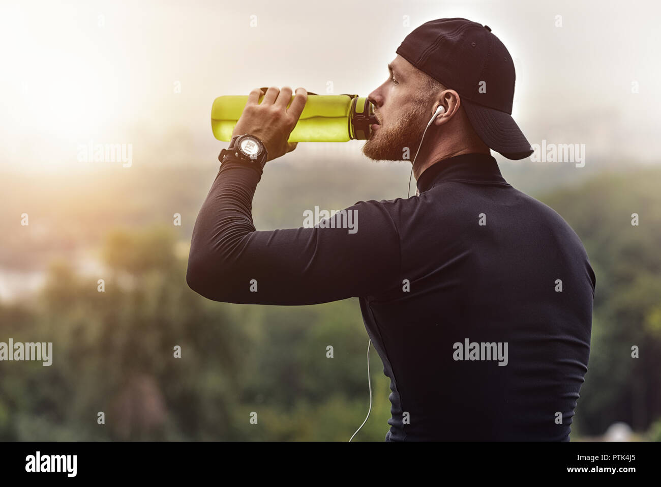Primerísimos barbudo hombre deportiva tomar un descanso y beber agua después de una sesión de ejercicio físico. Foto de stock
