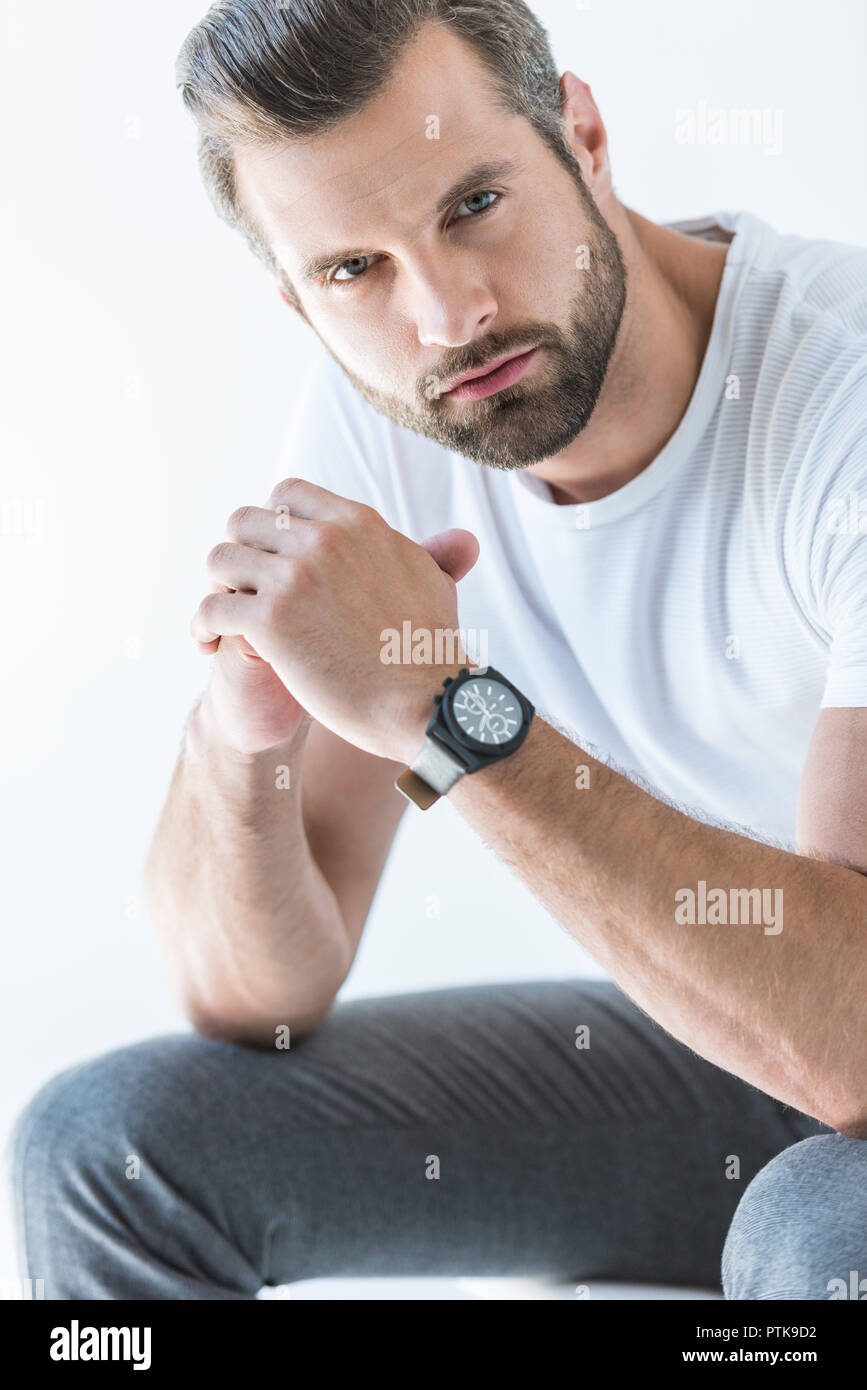 Barbudo hombre guapo en camiseta blanca con reloj de pulsera, aislado en blanco Foto de stock