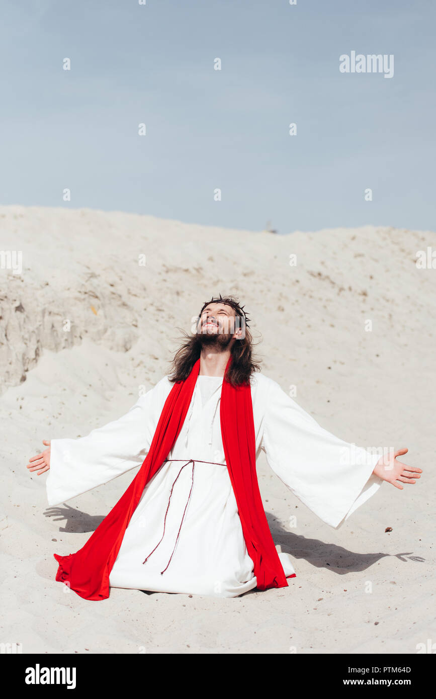 Imagen recortada de Jesús de túnica y fajín rojo en el desierto permanente  Fotografía de stock - Alamy
