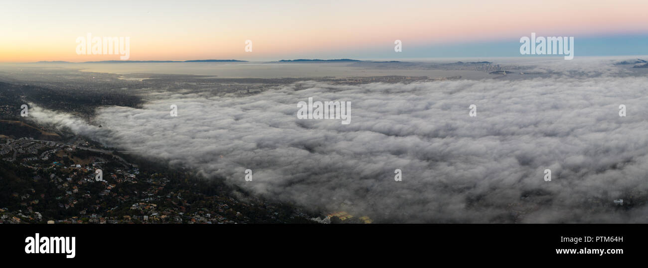 Amanecer ilumina la omnipresente capa marina que va a la deriva en el área de la Bahía de San Francisco de California. Foto de stock