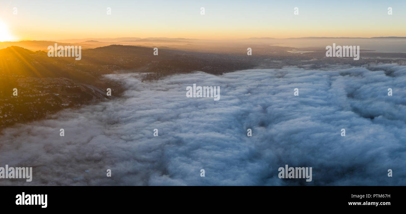 Amanecer ilumina la omnipresente capa marina que va a la deriva en el área de la Bahía de San Francisco de California. Foto de stock