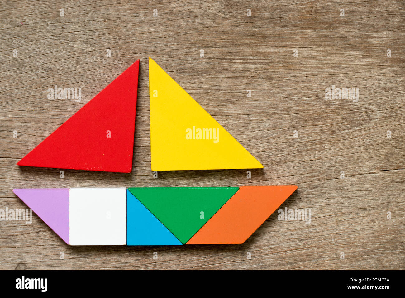 Colorido tangram en barco de vela en forma de fondo de madera Fotografía de  stock - Alamy