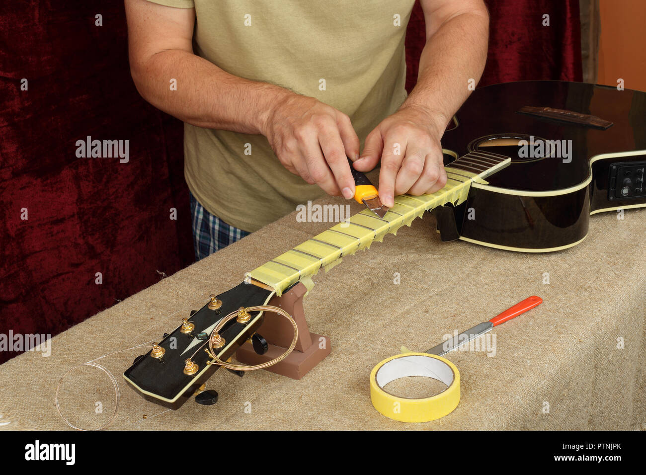 Guitarra instrumentos musicales - Reparación y servicio de preparación de  trabajadores pegar de trastes para guitarra acústica negra de molienda  Fotografía de stock - Alamy