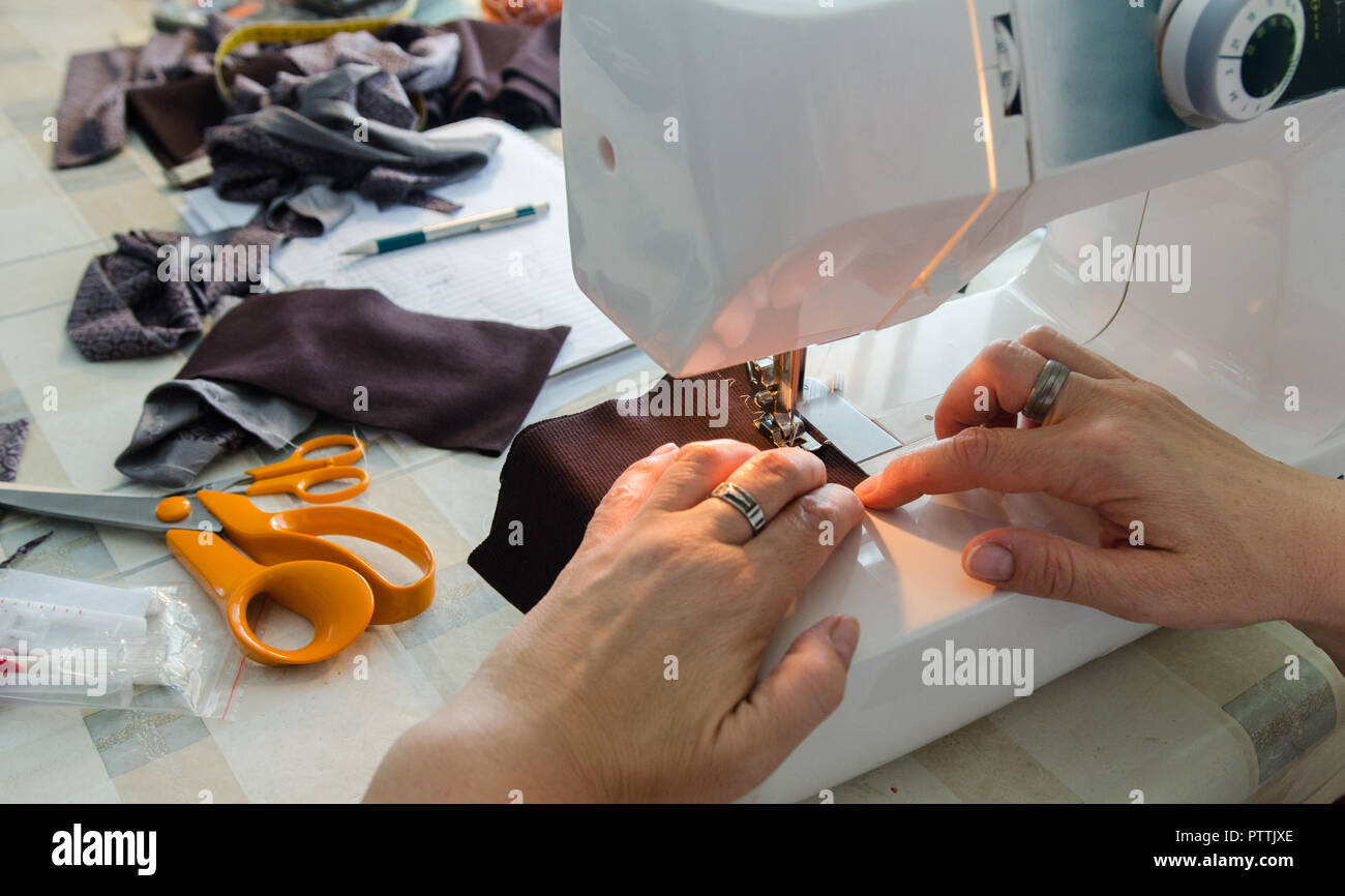 Mujer manos coser una pieza de ropa Foto de stock