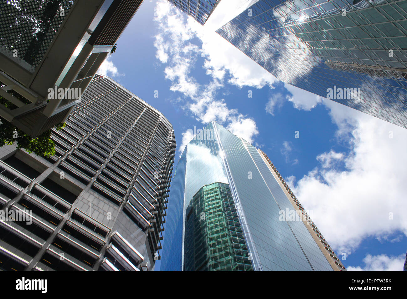 Mirando hacia los rascacielos con el cielo y las nubes reflejados en ellos Foto de stock