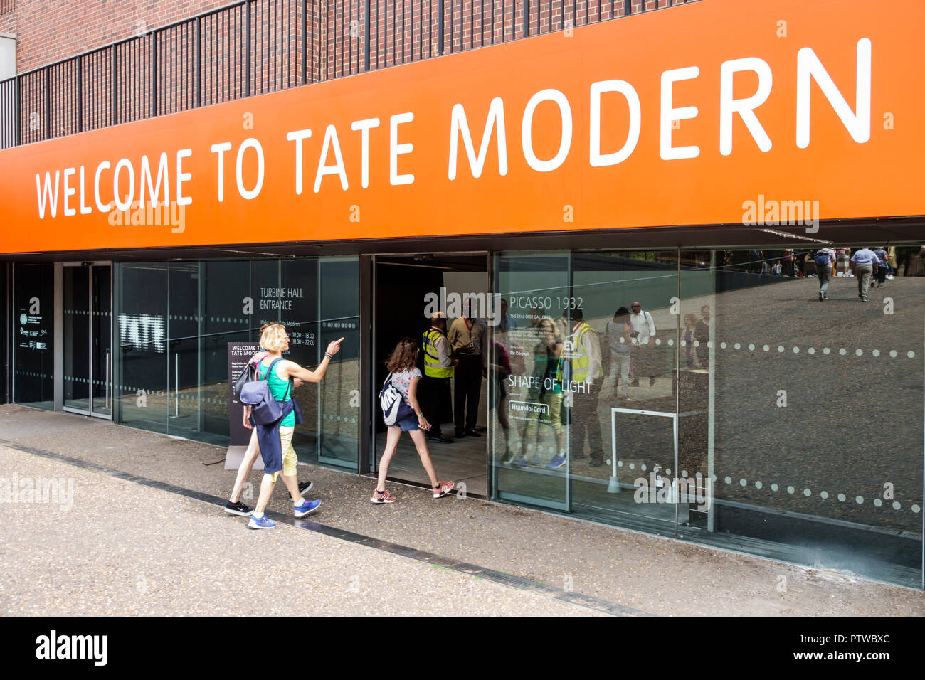 Londres Inglaterra,Reino Unido,Southwark,Bankside,Tate Modern,galería del museo de arte contemporáneo,puerta de entrada,señal de bienvenida,exterior,mujer mujer mujer mujer,chica g Foto de stock