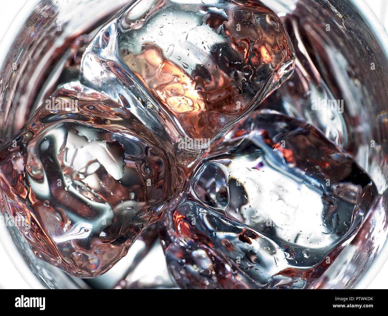 Cerrar cubitos de hielo en el vaso para beber con reflejos Foto de stock