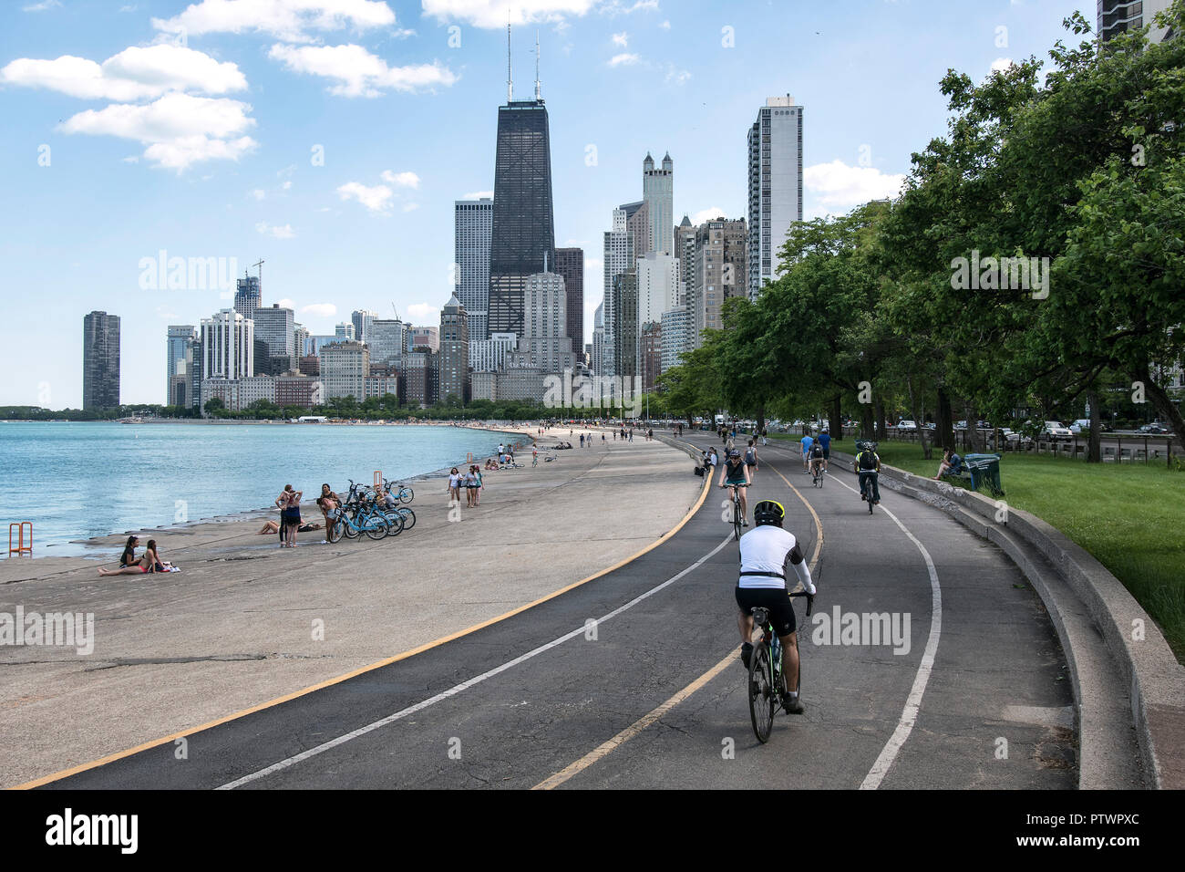 Ciclista en el Lakefront Trail a lo largo del Lake Shore Drive con vistas al horizonte de Chicago, Illinois, EE.UU. Foto de stock