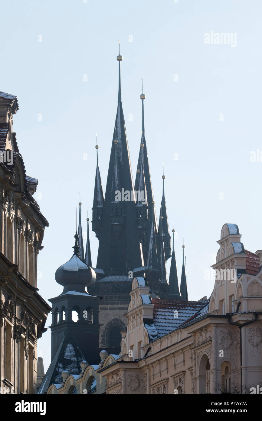 La Iglesia de Nuestra Señora en frente del Týn y el Castillo de Praga en una nevada noche sunset. La ciudad más grande de la República Checa, que es también la capital. Foto de stock