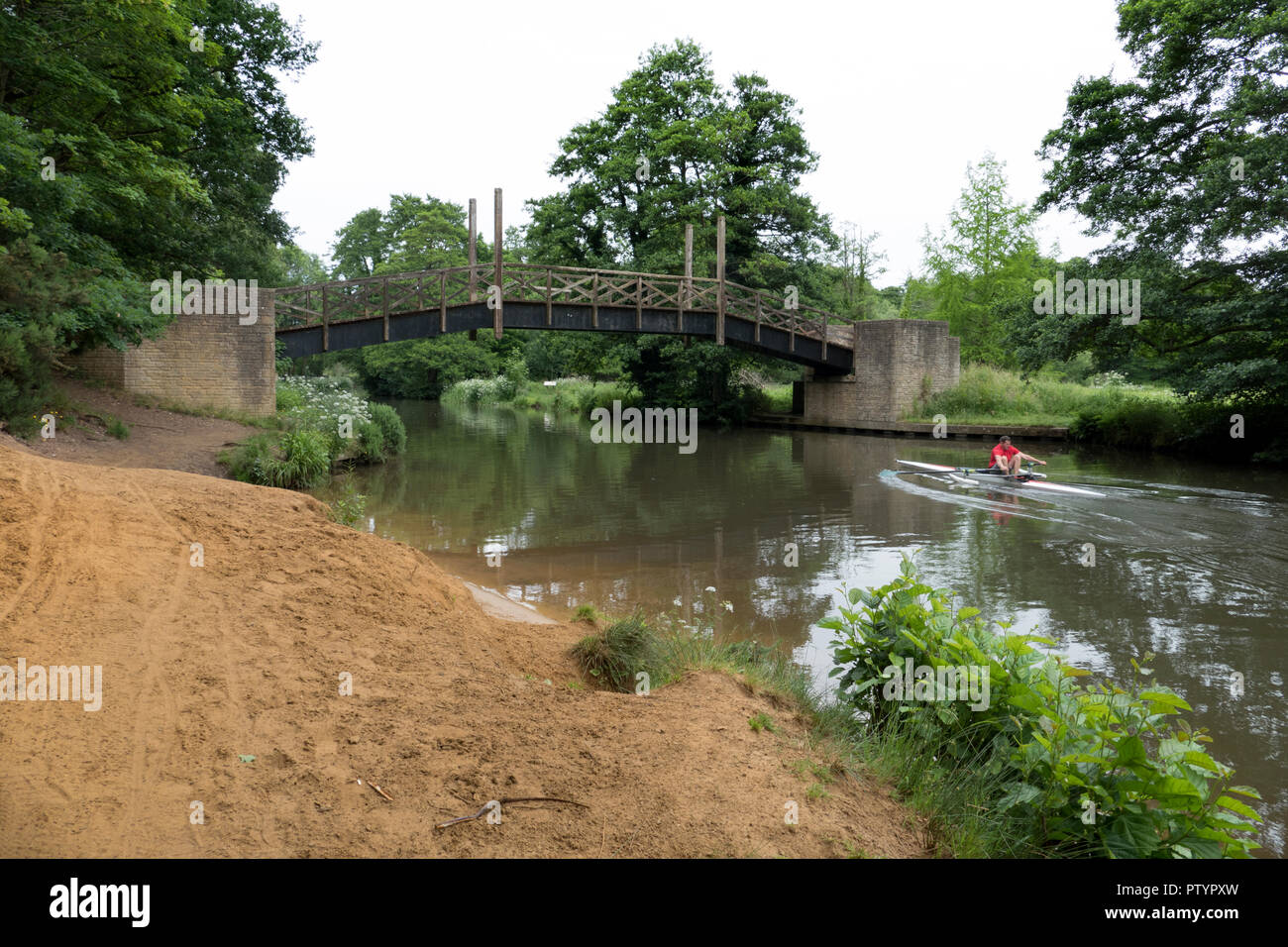 Un bote de remos se aproxima a un pintoresco puente sobre el río forma cerca de Guildford en Surrey, Inglaterra. Foto de stock