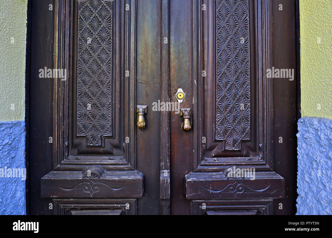 La orgullosa puerta frontal de una casa en Arganil, Centro de Portugal,  mostrando dos empujadores, accionados puertas lado de latón y ornamentadas  puertas de madera tallada Fotografía de stock - Alamy