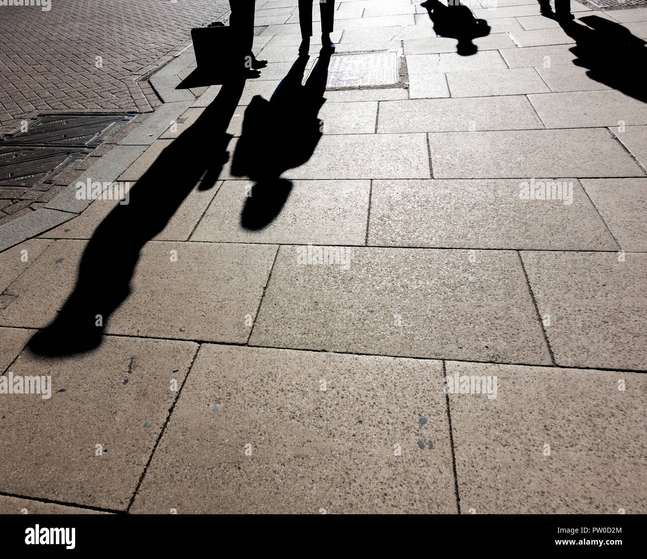 Los pueblos sombras sobre pavimento Foto de stock