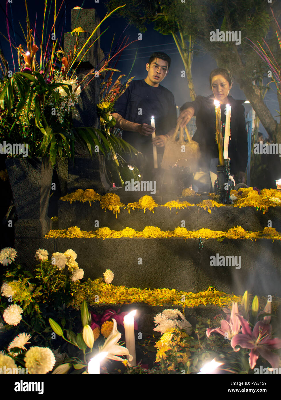 Los hombres recordar a los seres queridos en el histórico Cementerio CDMX Mixquic en el día de los Muertos Foto de stock