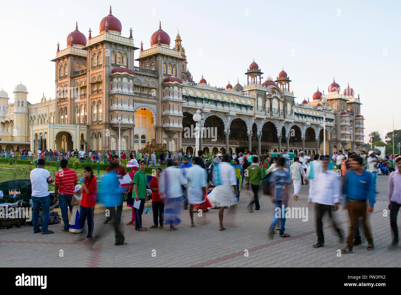 La India, Karnataka, Mysore, Palacio de la ciudad, la gente caminando fuera del palacio del maharajá Foto de stock