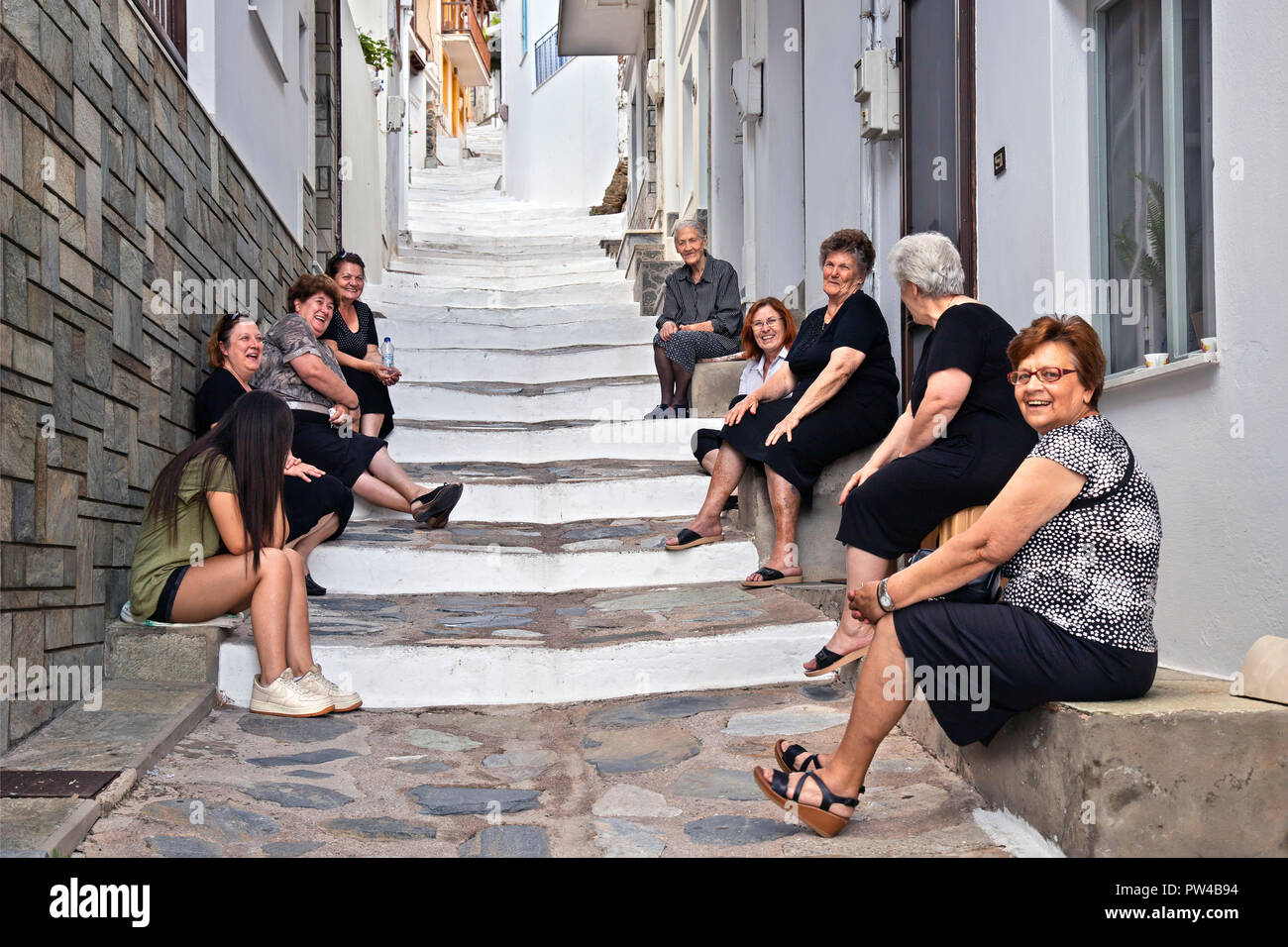 Señoras sentarse y conversar en una escalera de Skopelos town, en el norte de la Isla de Skopelos, Espóradas Magnessia, Tesalia, Grecia. Foto de stock