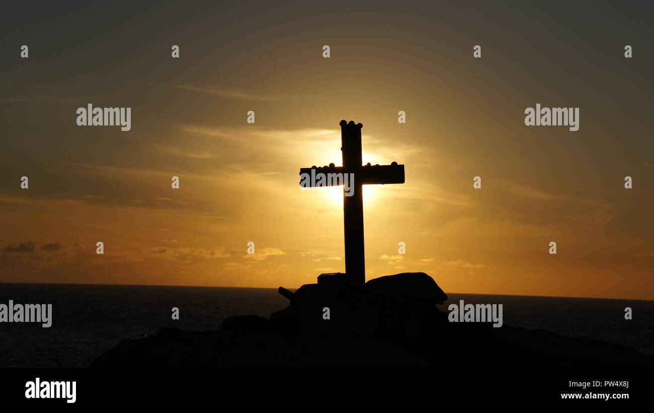 Los religiosos Cross Memorial silueta contra un cielo amarillo y naranja atardecer Foto de stock