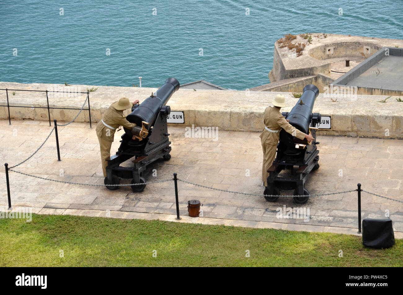 El disparo de la pistola de mediodía en la capital maltés de La Valeta. La ceremonia se lleva a cabo cada día en la batería que saludaba en el Upper Barracca gardens Foto de stock