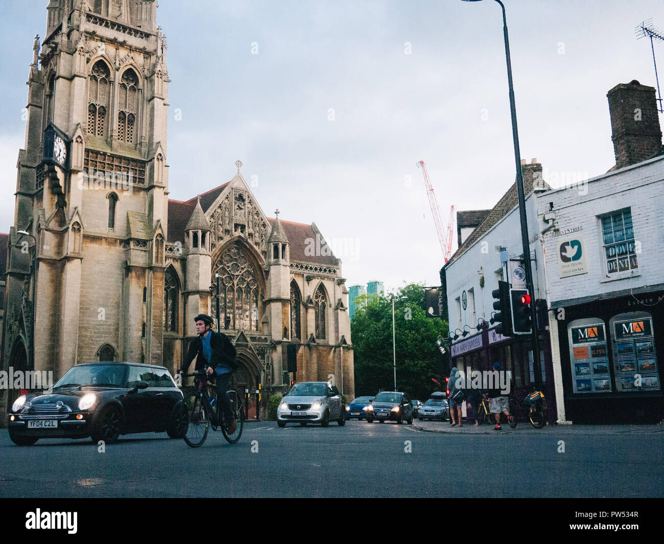 Nuestra Señora de los Mártires ingleses visto desde el lado opuesto del cruce con el movimiento de automóviles y un ciclista Foto de stock
