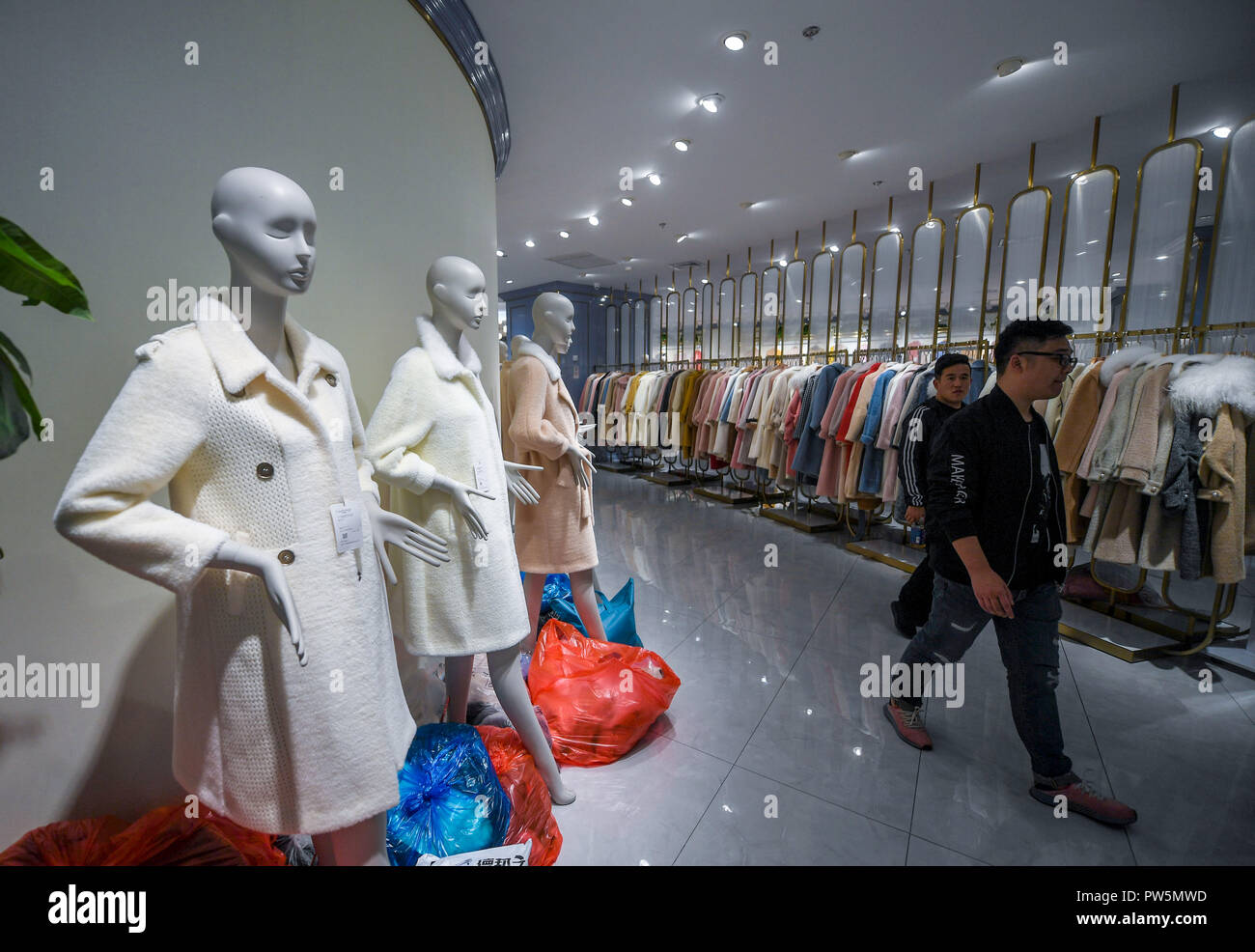 (181012) -- TONGXIANG, 12 de octubre de 2018 (Xinhua) -- Foto tomada el 11 de octubre de 2018, muestran que los clientes de compras en una tienda en la ciudad Puyuan suéter en Tongxiang, provincia de Zhejiang de China oriental. Puyuan, un pequeño pueblo de la provincia de Zhejiang, es considerado como el mayor centro comercial para el jersey de lana de China. Posee 19 zonas comerciales, más de 10.000 empresas suéter suéter y más de 10.000 tiendas. Un gran número de comerciantes y mercancías que entran y salen de la ciudad ha hecho su suéter comercio representan el 60 por ciento del total nacional. (Xinhua/Xu Yu) (wyl) Foto de stock