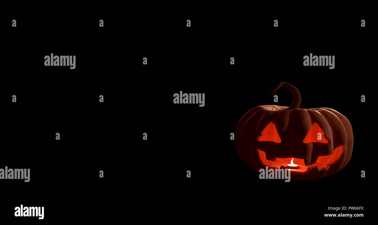 Halloween calabaza con cara de miedo sobre fondo negro. Foto de stock