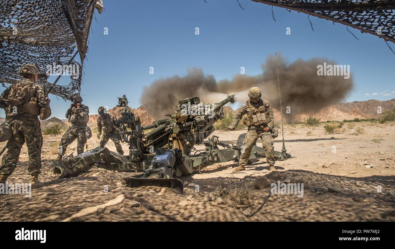 Infantes de Marina de los Estados Unidos asignado al 11º Regimiento de la Infantería de Marina, la primera división de infantería de marina, disparar un obús M777 durante el curso de Instructor de armas y tácticas (WTI) 1-18 en la antena de la montaña de Chocolate Tiro, California, 26 de septiembre de 2017. El WTI es un evento de capacitación de siete semanas organizado por la Aviación Marina armas y tácticas de escuadrón MAWTS Uno (cuadro 1), haciendo hincapié en la integración operacional de las seis funciones de aviación del Cuerpo de Infantería de Marina en apoyo de una masa de aire marino Task Force. Foto de stock