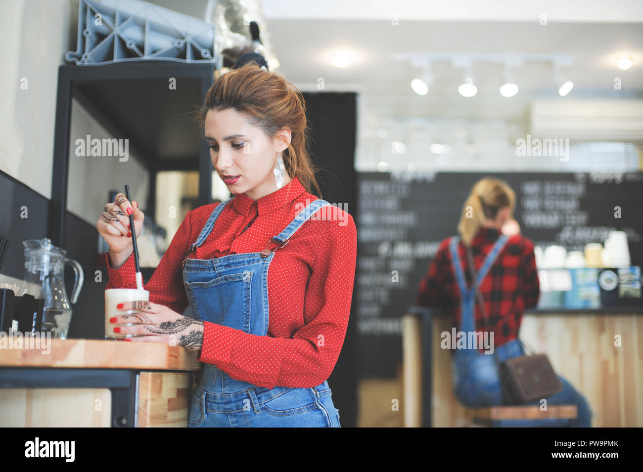 Moda joven en camisa roja y traje de dril de algodón mezclado con paja en  su café bar Fotografía de stock - Alamy
