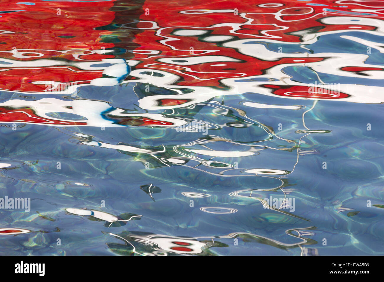 Una imagen abstracta de un barco roja reflejada en el agua Foto de stock