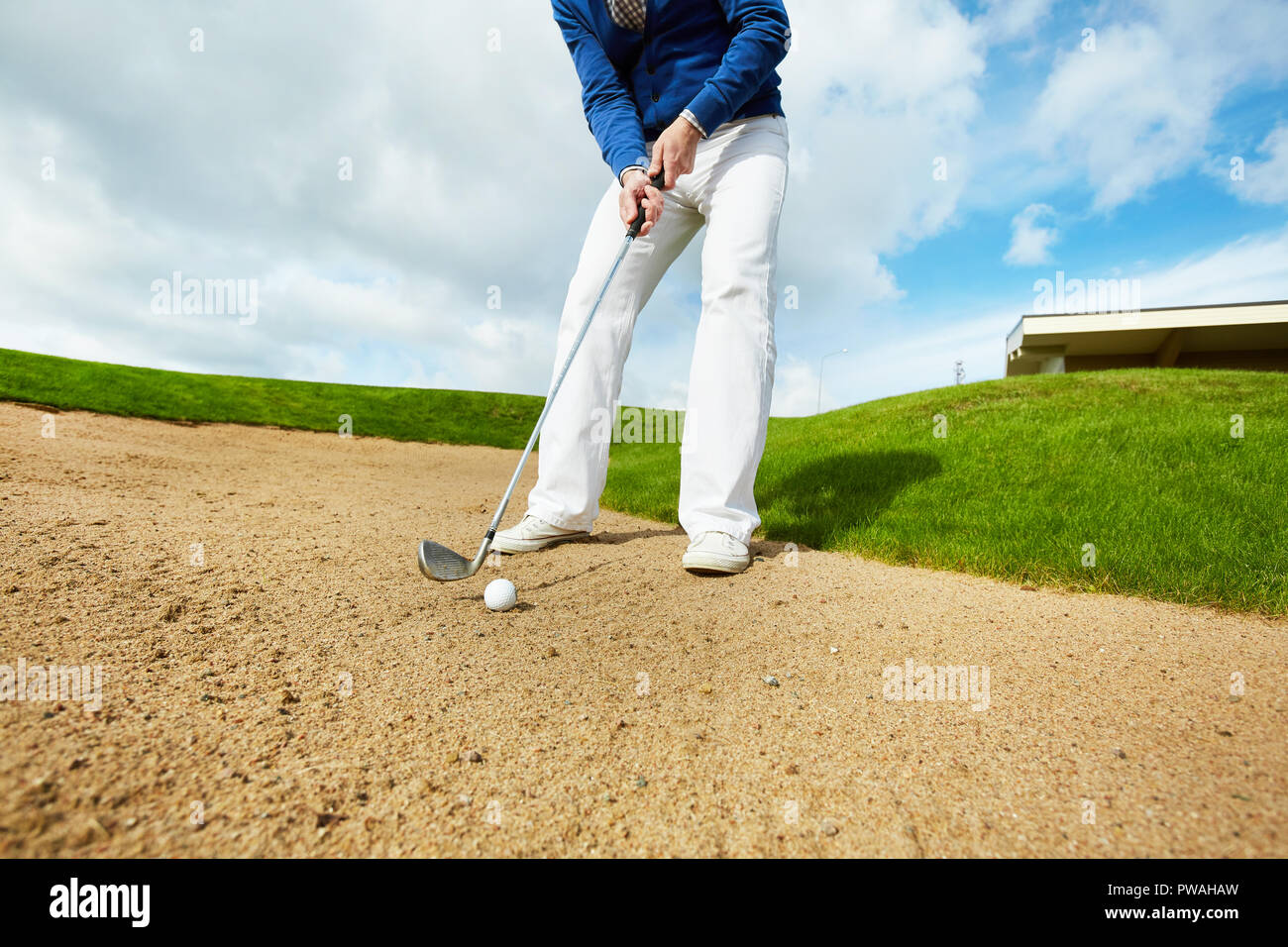 Demon Play Kent Injerto Hombre activo en color blanco, pantalones y chaqueta azul en el suelo e ir  a golpear una pelota de golf Fotografía de stock - Alamy