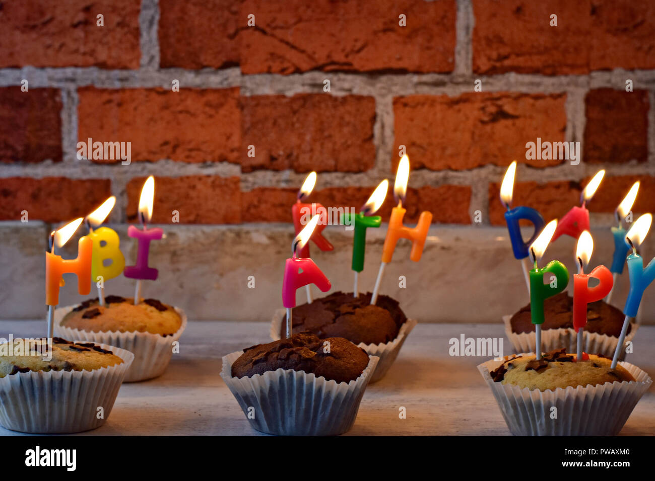 Deliciosas magdalenascupcakes whit quemando velas feliz cumpleaños en