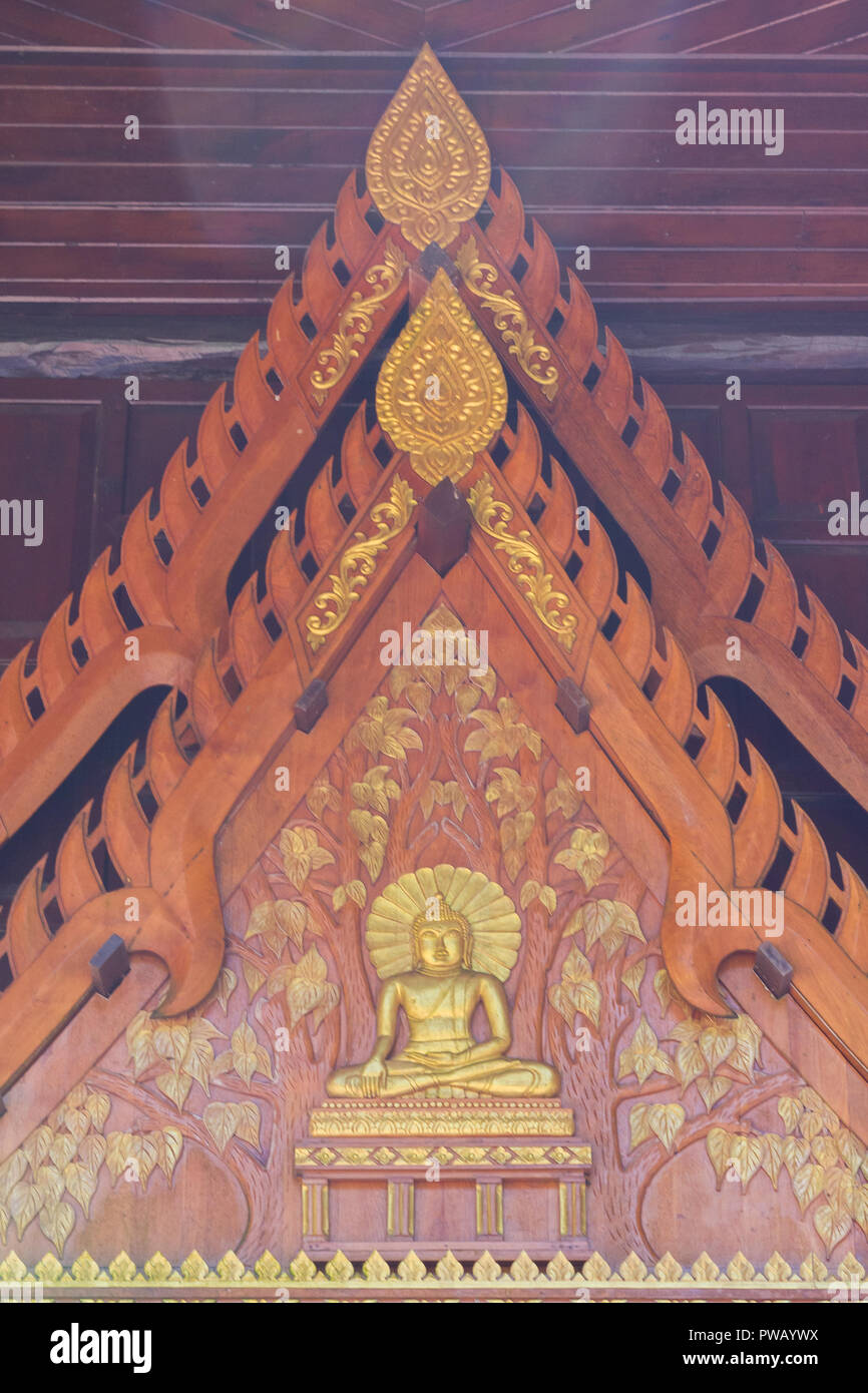 Un tallado de madera depictiong imagen de personas en la pared del templo en Tailandia Foto de stock