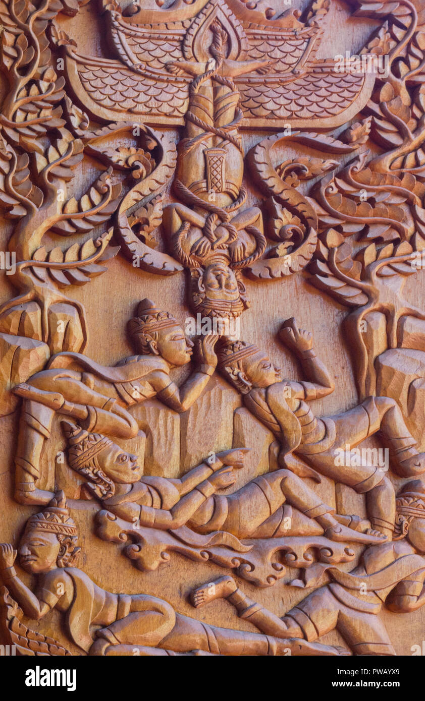 Un tallado de madera depictiong imagen de personas en la pared del templo en Tailandia Foto de stock