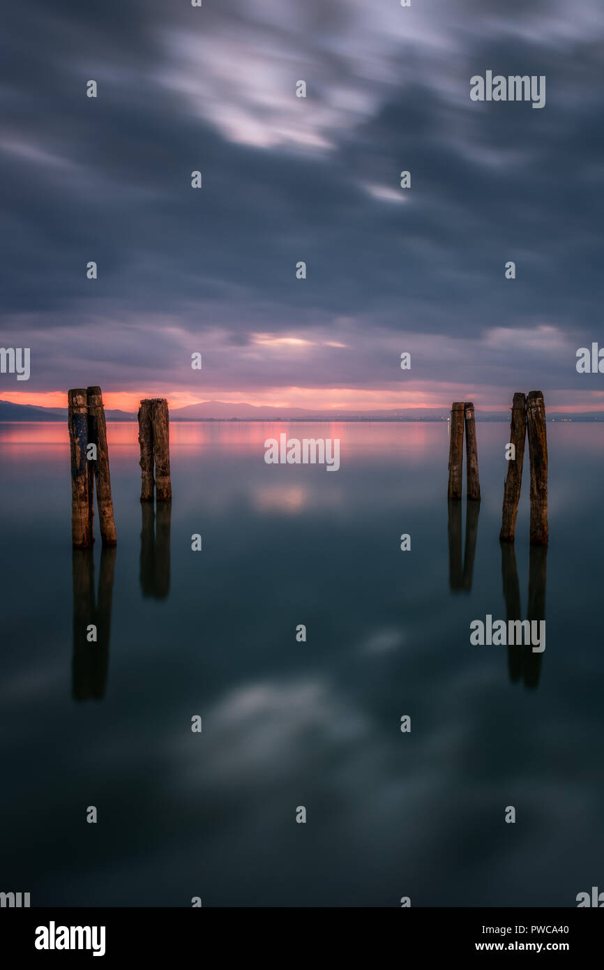 Puesta de sol sobre el Lago Trasimeno, día nublado. Como el reflejo del espejo. Paisaje italiano. Foto de stock