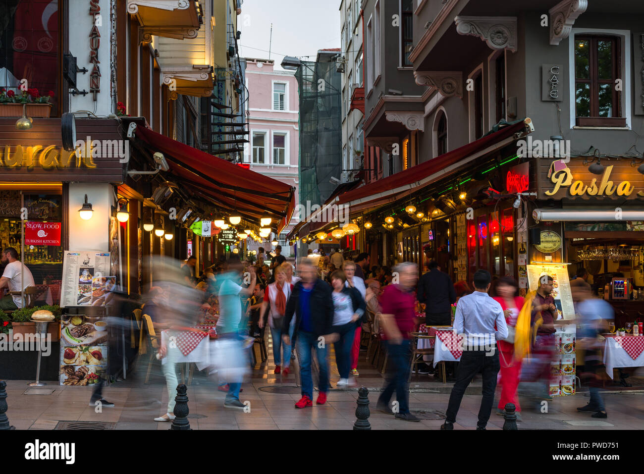 Un restaurante con comedor al aire libre al atardecer como la gente camina pasado, Estambul, Turquía Foto de stock
