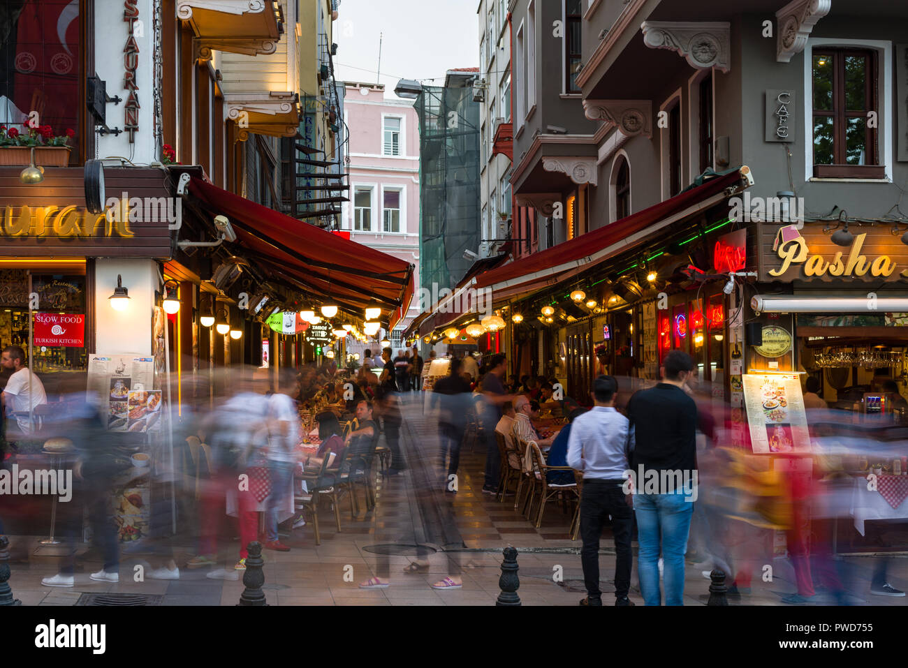 Un restaurante con comedor al aire libre al atardecer como la gente camina pasado, Estambul, Turquía Foto de stock