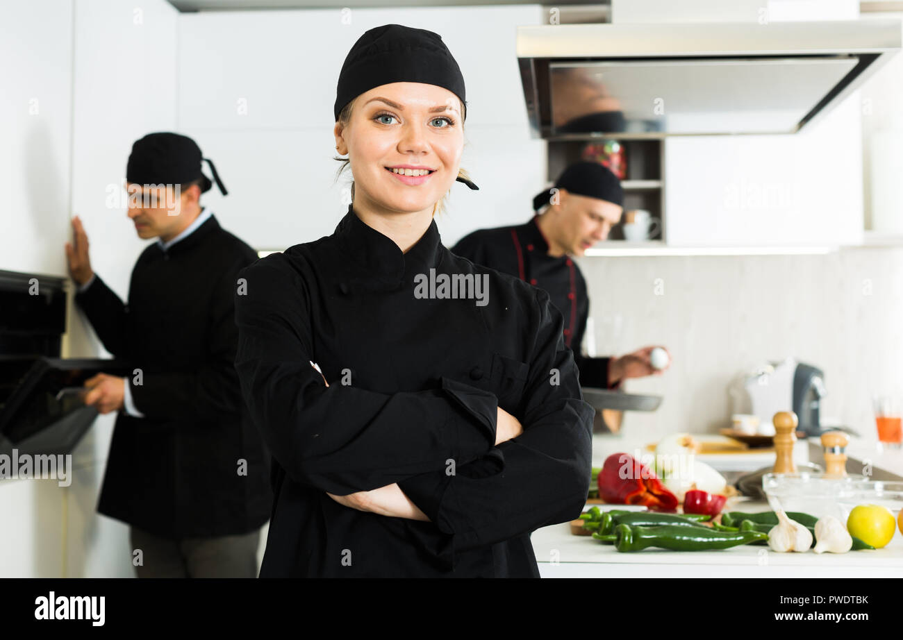 familia melodía abuela Mujer profesional chef en uniforme negro de pie cerca de lugar de trabajo  en la cocina Fotografía de stock - Alamy