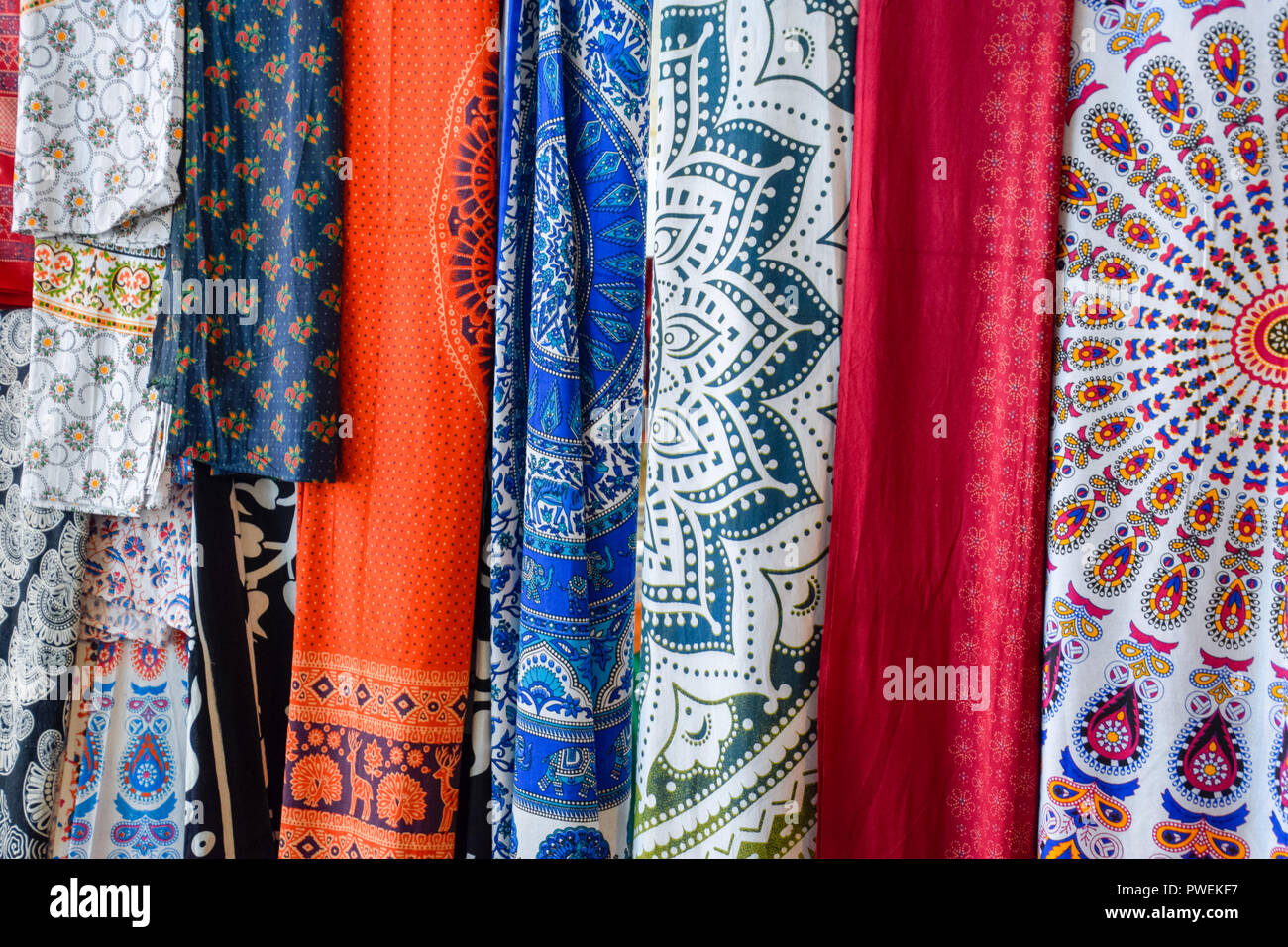 Telas indias colgando sobre el mostrador. El comercio de telas de la India.  Telas con patrones y patrones Fotografía de stock - Alamy