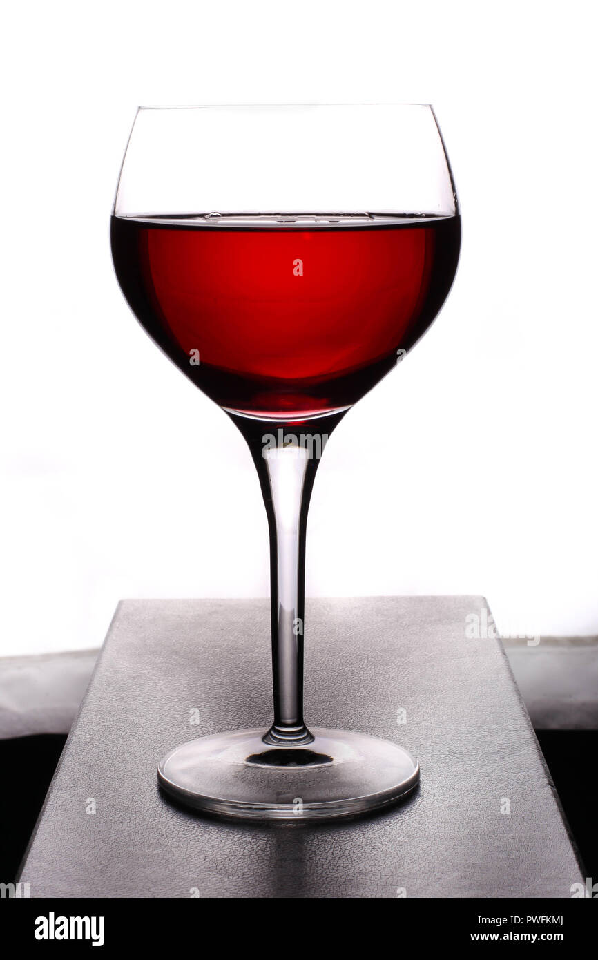 Cristal con vino rojo sobre fondo blanco. Foto de stock