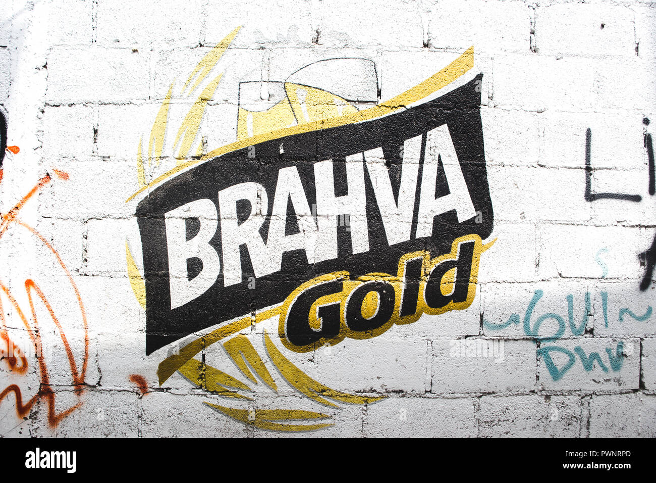 Logotipo de cerveza Brahva Oro pintada en una pared en medio de graffiti en Guatemala Foto de stock