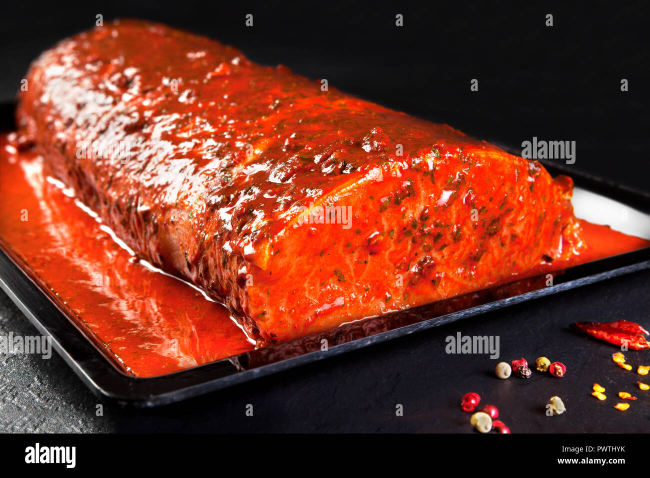 Pieza Entera De Lomo De Cerdo Marinado Listo Para Cocinar Bandeja De Filetes De Lomo Sobre Fondo Negro Con Perejil Fotografia De Stock Alamy