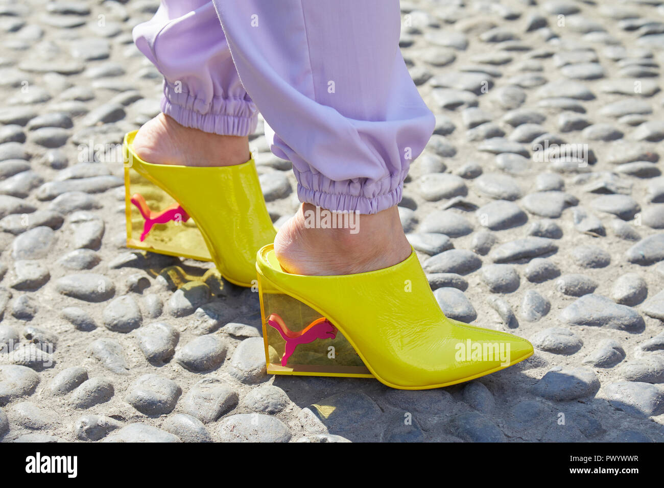 Milán, Italia - 21 de septiembre de 2018: Mujer con zapatos Puma amarillo transparente con talón y pantalón púrpura antes Show, Milán Fashio Fotografía de stock - Alamy