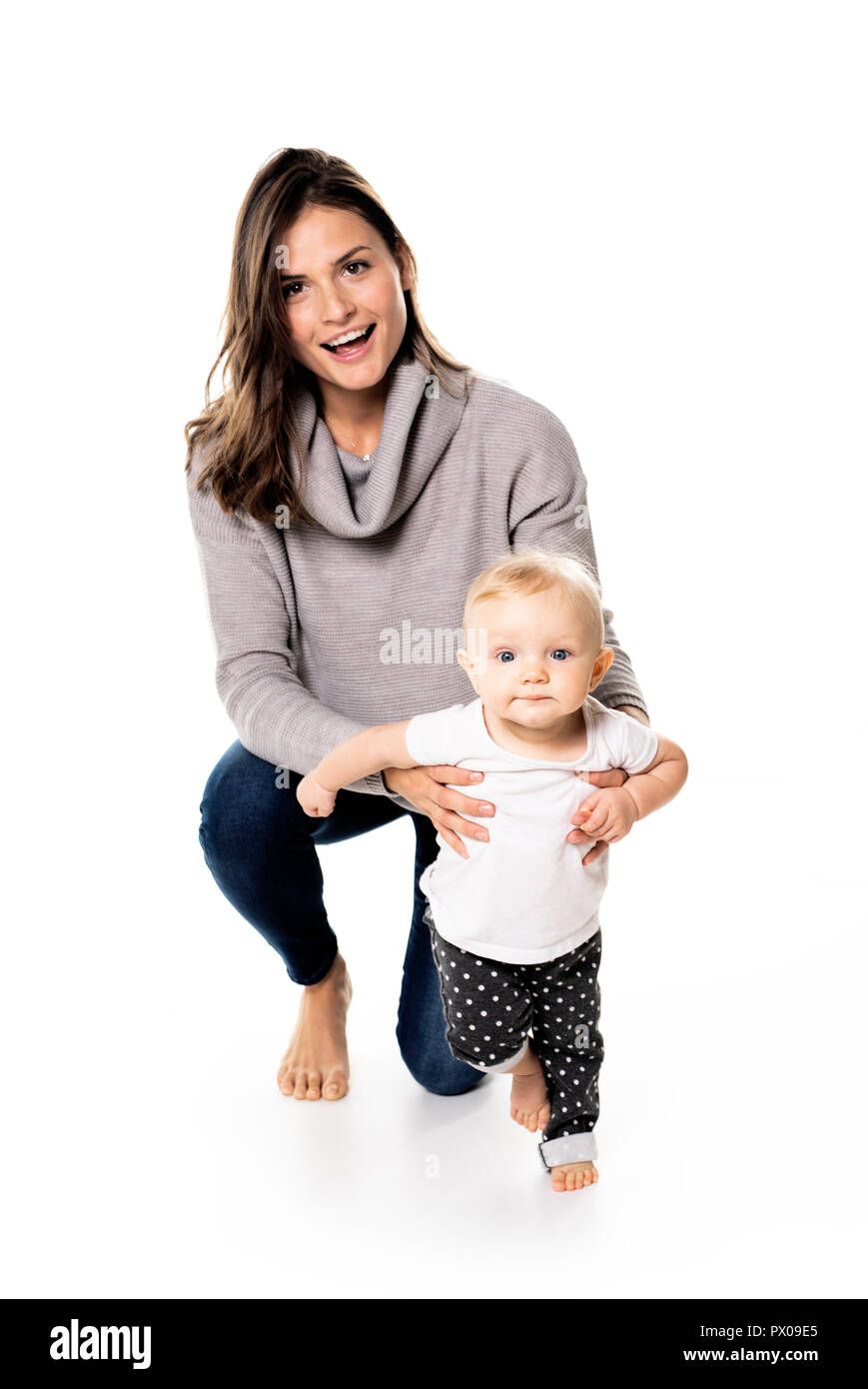 Una madre a su bebé holdng studio sobre fondo blanco. Foto de stock