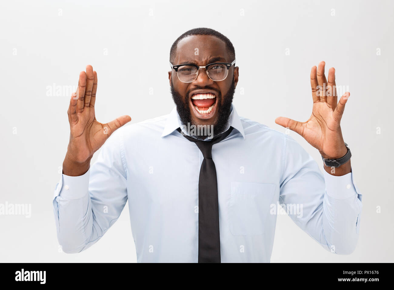 Retrato de molesto macho negro desesperados gritos de rabia y enfado desgarrando su cabello mientras se sentía furioso y enojado con algo. Rostro humano negativo expresiones, emociones y sentimientos. Foto de stock