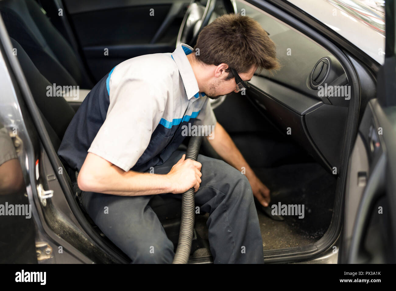 Mechanic aspirar el coche en el garaje Fotografía de stock - Alamy