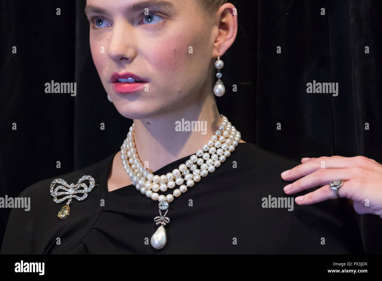 Londres, Reino Unido. 19 de octubre de 2018. Un modelo lleva las joyas de María  Antonieta (L A R) Diamond Brooch, la segunda mitad del siglo XVIII (Est.  USD 50K-80K), perla natural