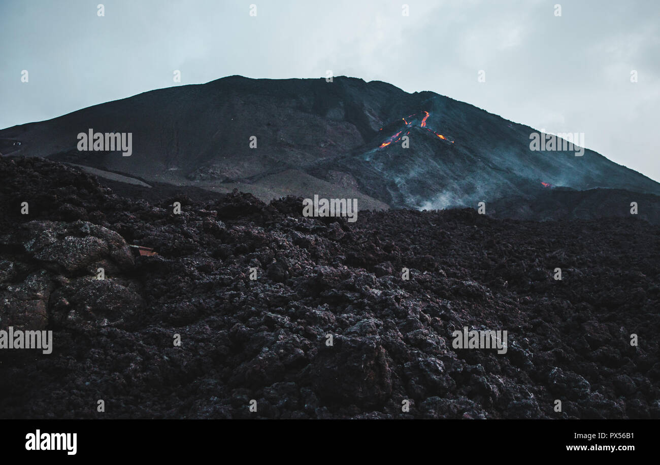 Pequeña roca volcánica y la lava fluyendo hacia abajo Volcán Pacaya, uno de los volcanes más activos de Guatemala. Foto de stock