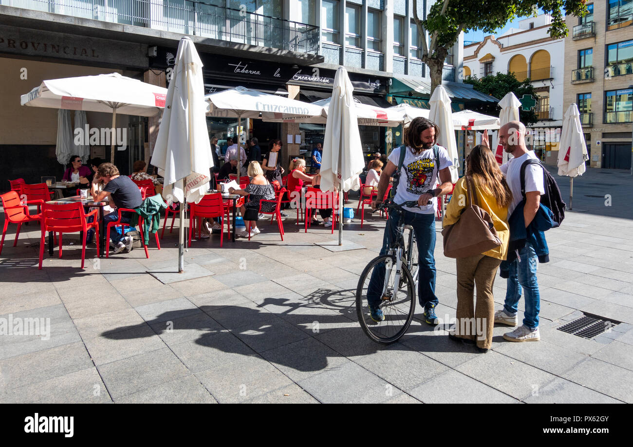 Tres amigos se encuentran fuera de un café de Sevilla en España Fotografía  de stock - Alamy