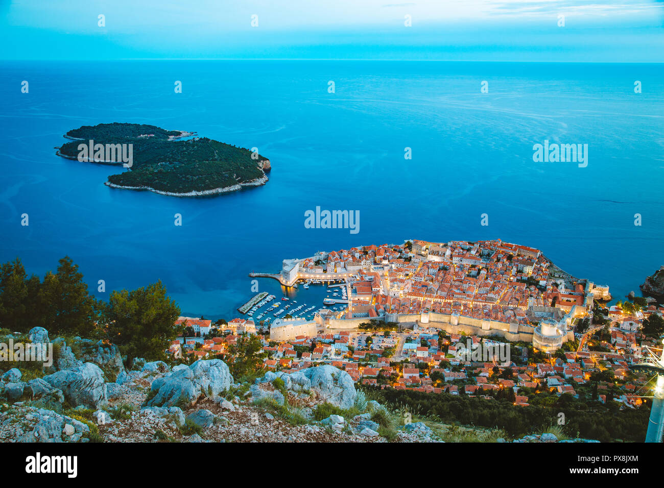 Vista aérea panorámica de la histórica ciudad de Dubrovnik con Lokrum Island en el hermoso crepúsculo vespertino al anochecer, Dalmacia, Croacia Foto de stock