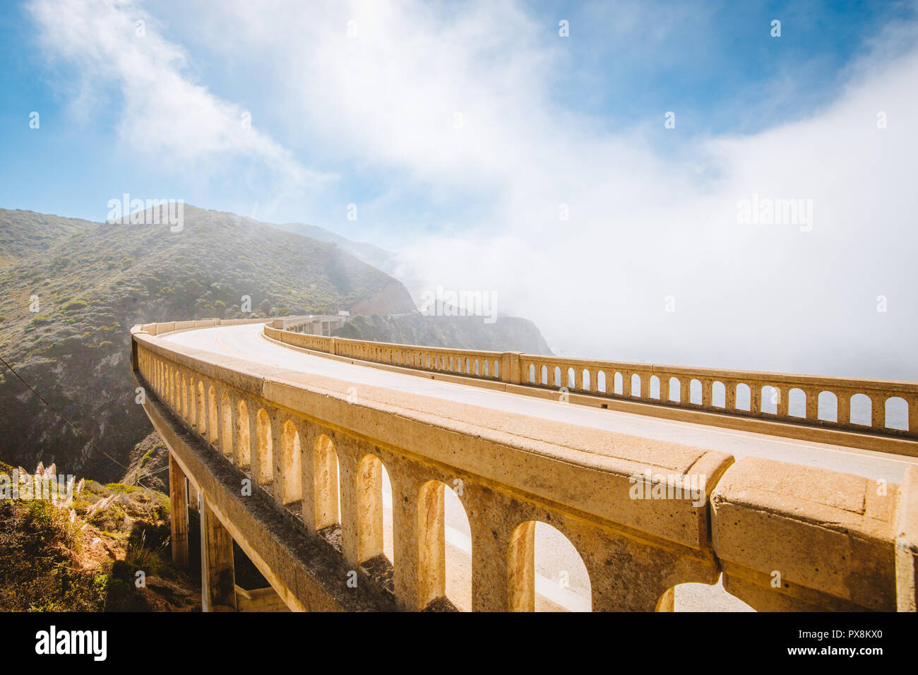 Vista panorámica del casco histórico de Bixby Creek mundialmente famoso puente a lo largo de la autopista 1 en un día soleado, con niebla, en verano, el Condado de Monterey, California, EE.UU. Foto de stock