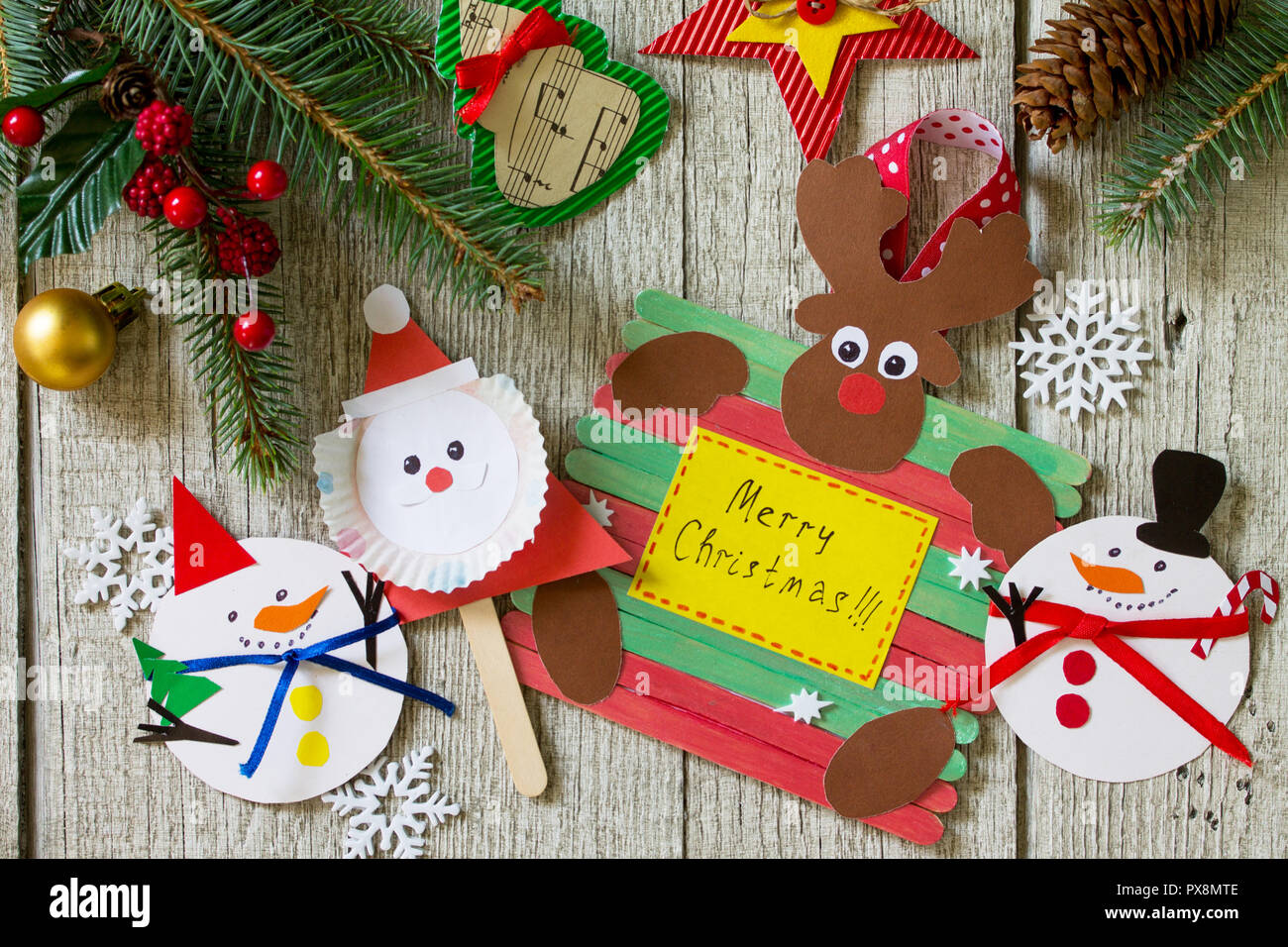 Feliz Navidad Regalo en mesa de madera - Santa, renos y el muñeco de nieve  juguetes. Hecho a mano. Proyecto de la creatividad de los niños,  artesanías, manualidades para niños Fotografía de