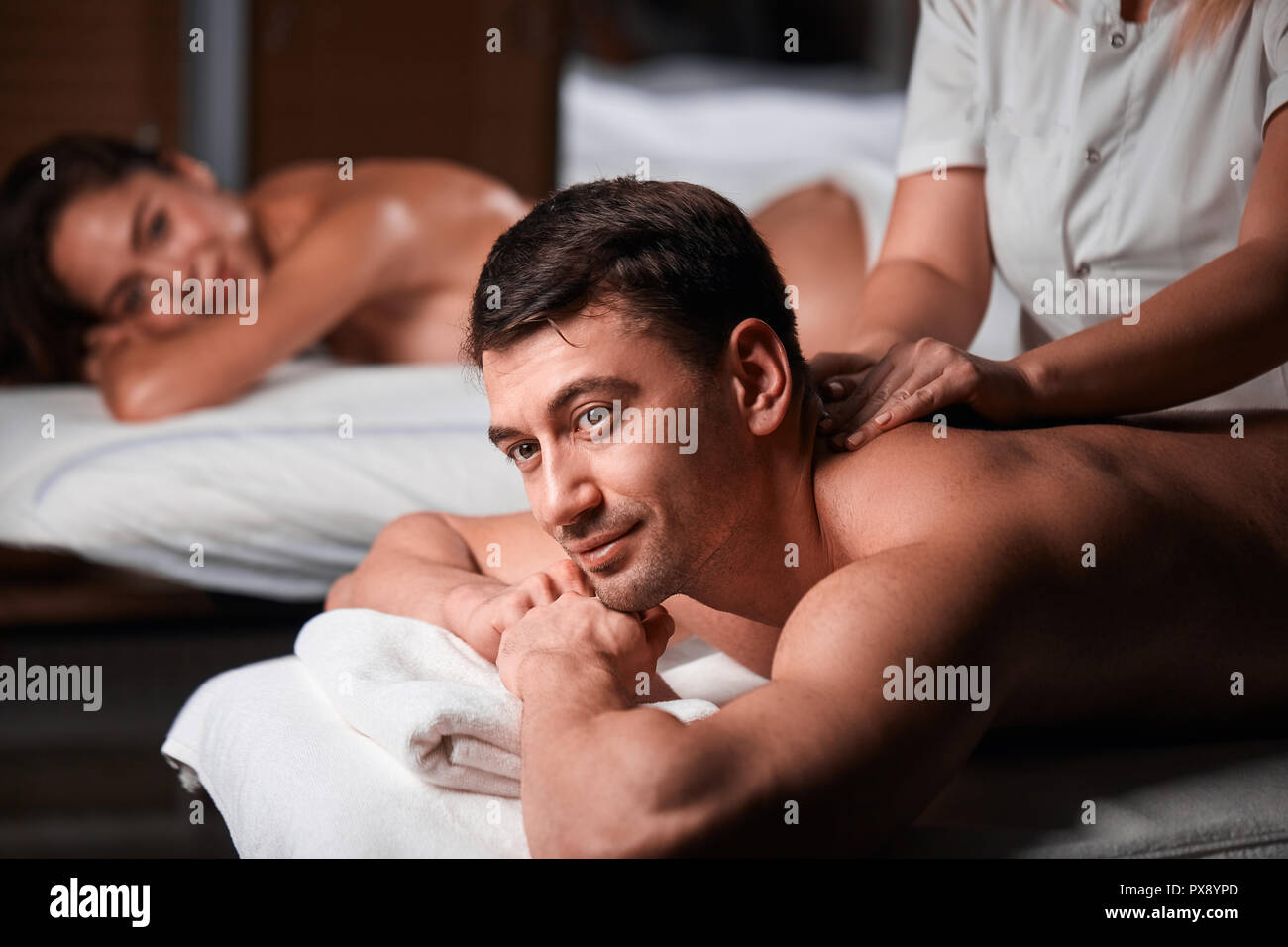 Pareja joven recibiendo un masaje de espalda en un centro Spa Fotografía de stock